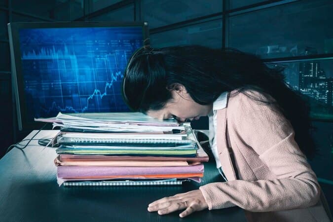 A woman overwhelmed by data overload while trying to sift through information